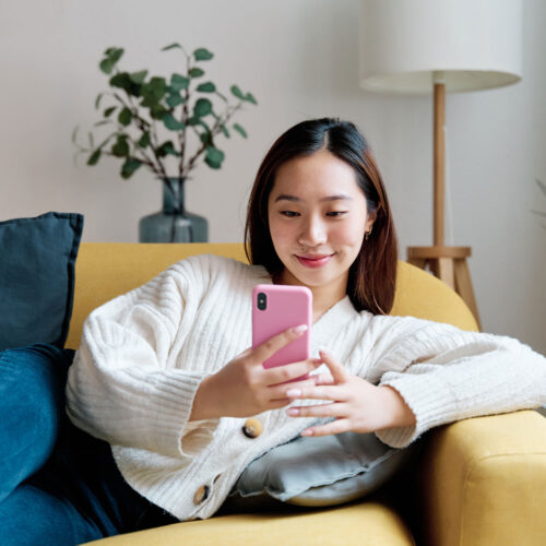 cheerful-asian-woman-using-smartphone